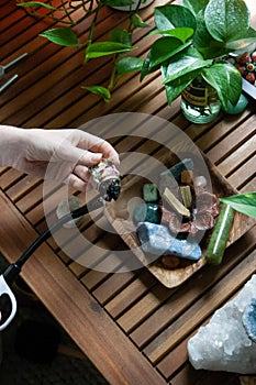 Woman Lighting a Smudge Stick With Crystals