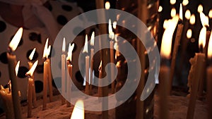 Woman lights a candle in a church, close-up
