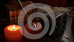 A woman lights candles with Christmas decorations.