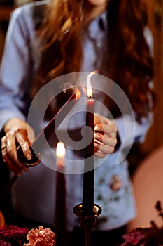 A woman lights candles at Christmas party. Blurred background and selected
