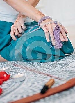 Woman with lilac mala beads on her hands henna mehendi