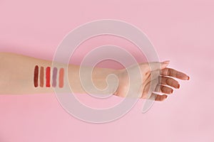 Woman with lipstick swatches on color background