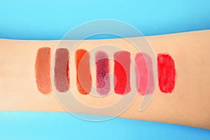 Woman with lipstick swatches on color background