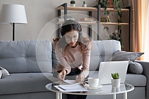 Woman listen audio course make notes use videoconference on laptop