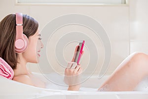 Woman listen music in bathtub