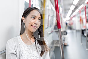 Woman listen to music on cellphone on train