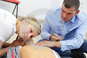 Woman listening for breath during first aid training course