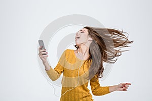 Woman listening music in headphones and dancing