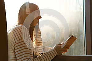 Woman listening to audiobook at table photo