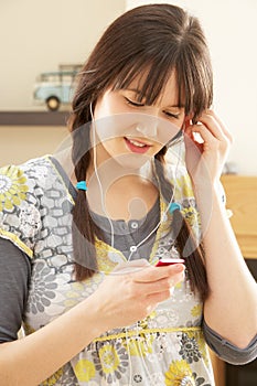 Woman Listening To MP3 Player On Headphones