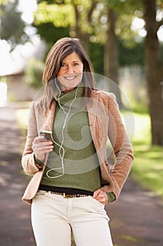 Woman Listening To MP3 Whilst Walking photo