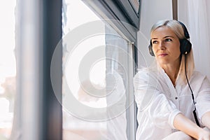 Woman listening to music, staring out the window