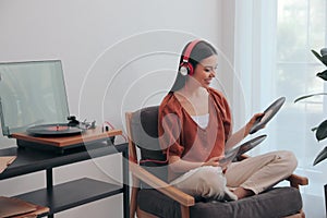 Woman listening to music with turntable at home