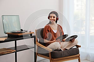 Woman listening to music with turntable at home