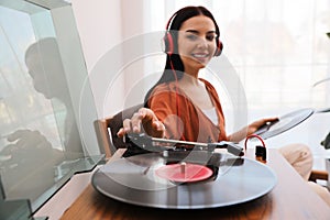 Woman listening to music with turntable at home