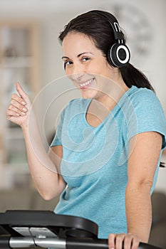 woman listening to music while using exercise machine