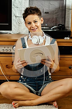 Woman listens to music and holds a vinyl record