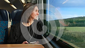 Woman listens to a player and goes on a train in Europe