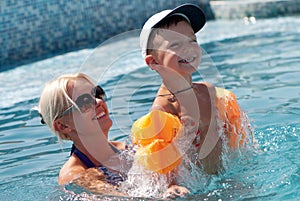 Woman and little boy bathes in pool