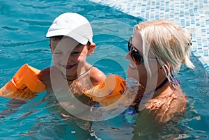 Woman and little boy bathes in pool