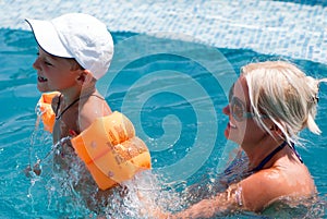 Woman and little boy bathes in pool photo