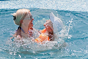 Woman and little boy bathes in pool