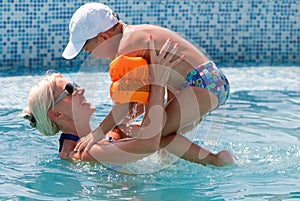 Woman and little boy bathes in pool