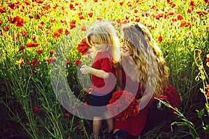 Woman and little boy or child in field of poppy