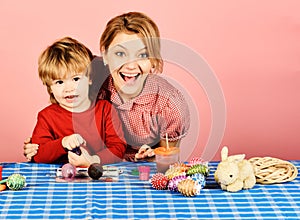 Woman and little boy with smiling faces making decorations