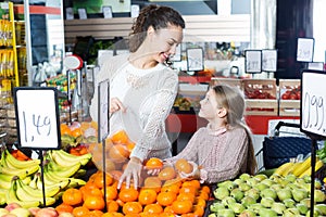 Woman and little girl buying fruits