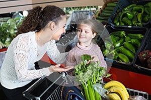 Woman and little girl buying veggies