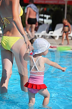 Woman and little girl going on paddling pool