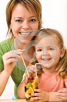 Woman and little girl having a fruity refreshment