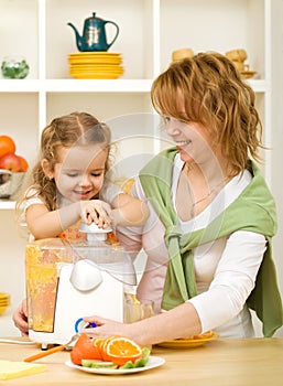 Woman and little girl making fruit juice