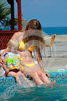 Woman and little girl making splash in pool