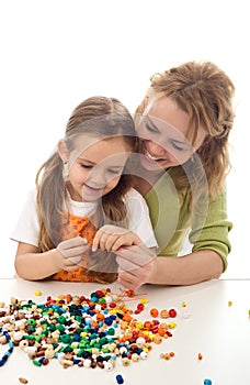 Woman and little girl playing with beads