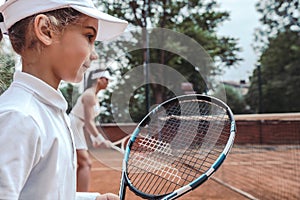 Woman and little girl playing tennis and waiting for the service