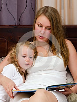 Woman and little girl read a book