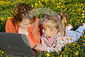 Woman and little girl relaxing on the flower field