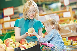 Woman and little girl shopping fruits