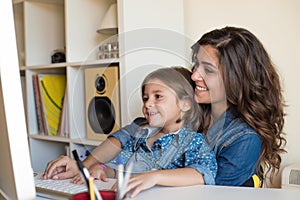 Woman and little girl using computer