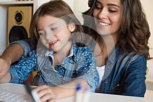 Woman and little girl using computer