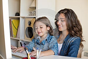 Woman and little girl using computer