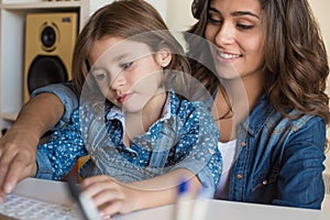 Woman and little girl using computer