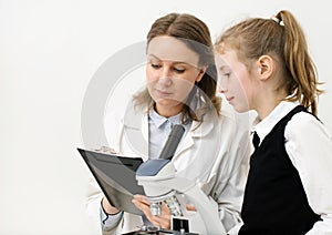 Woman and little girl using microscope.