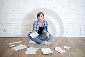 Woman at living room floor with calculator and bank and bills paperwork and documents doing domestic financial accounting