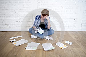 Woman at living room floor with calculator and bank and bills paperwork and documents doing domestic financial accounting