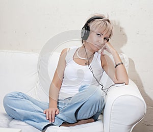 Woman in living room listening to MP3 player smiling