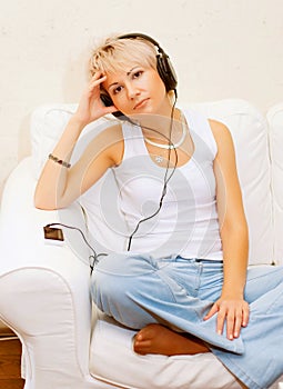 Woman in living room listening to MP3 player