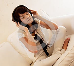 Woman in living room listening to MP3 player